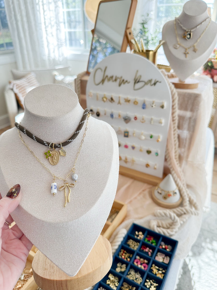 Knotting Tides Charm Bar with custom charm necklaces on display