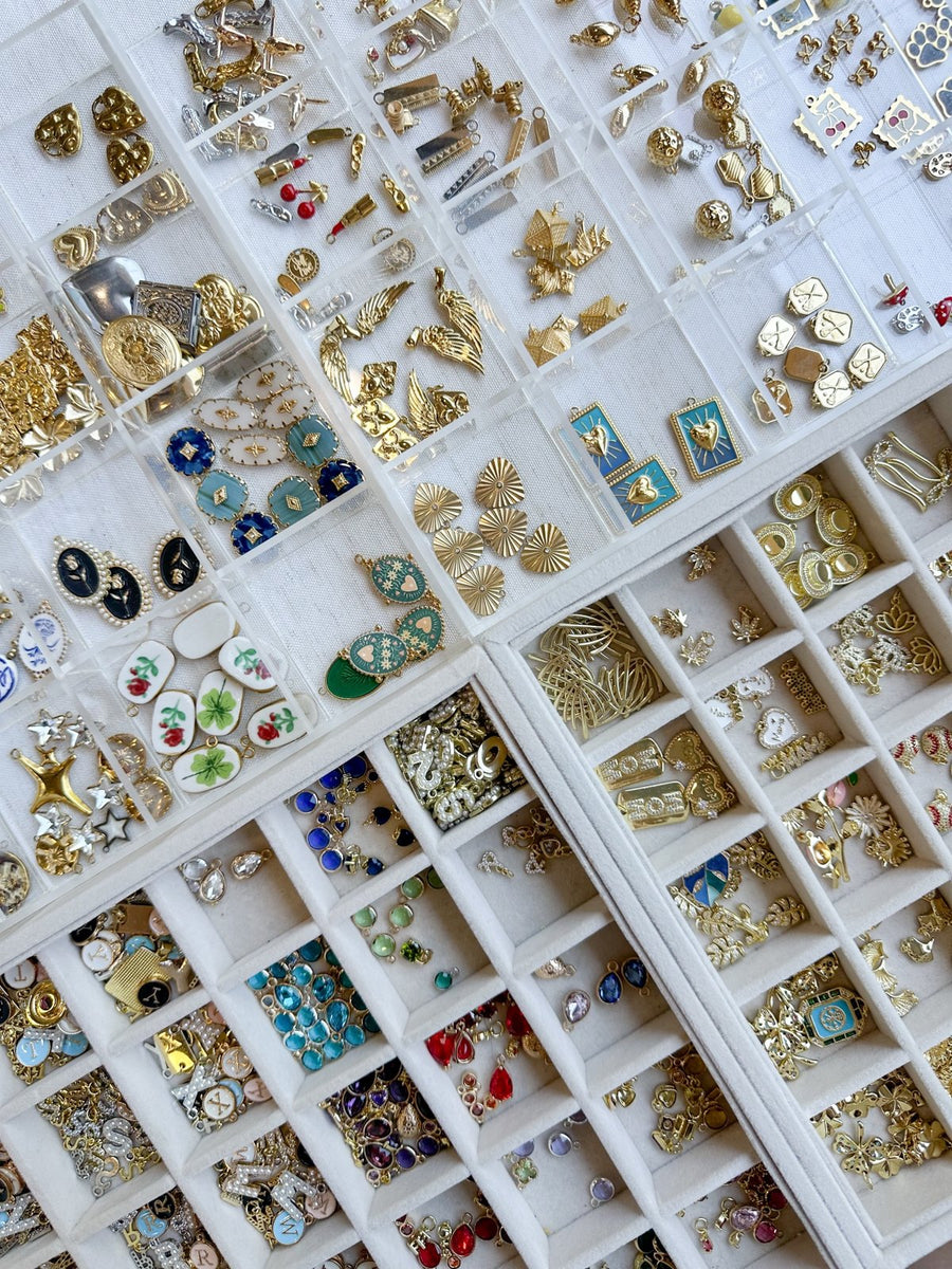 Trays of gold, enamel and crystal charms at the Knotting Tides Charm Bar